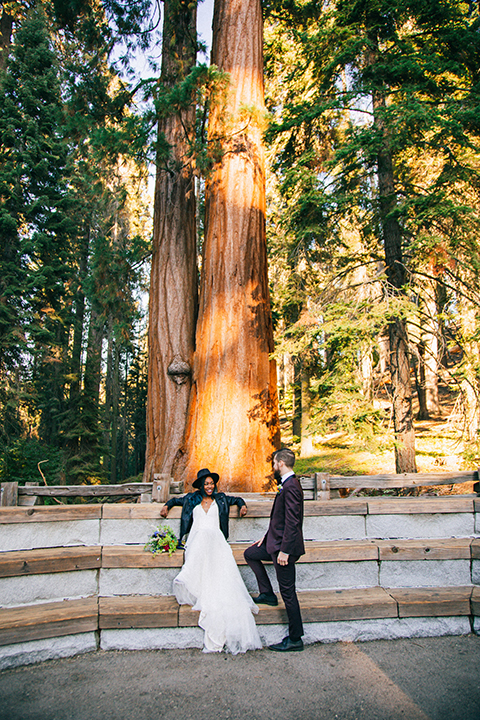  boho wedding with the ceremony inside and the reception on the cliffs overlooking the ocean and the bride in a finged gown and the groom in a tan suit 