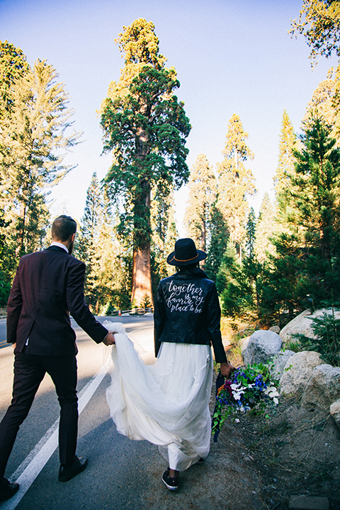  boho wedding with the ceremony inside and the reception on the cliffs overlooking the ocean and the bride in a finged gown and the groom in a tan suit 