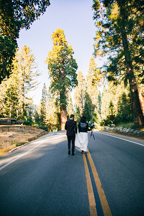  boho wedding with the ceremony inside and the reception on the cliffs overlooking the ocean and the bride in a finged gown and the groom in a tan suit 