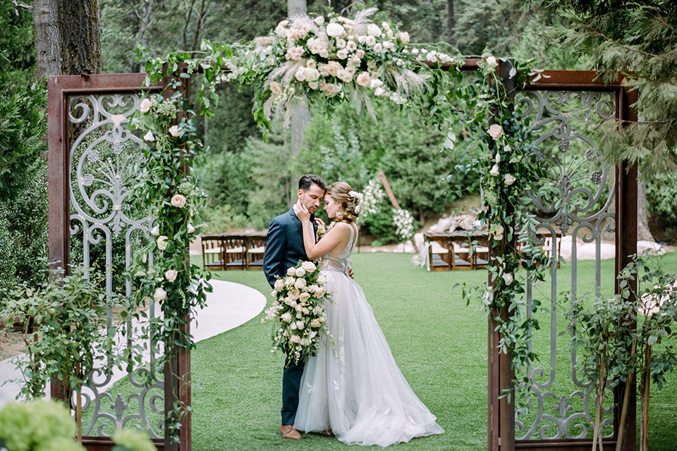  garden themed wedding with the bride in a light lilac colored gown and the groom in a navy suit with lots of wedding day flowers 