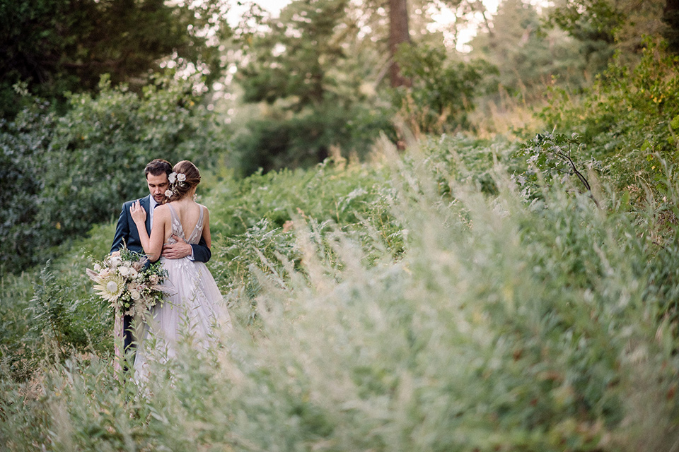  garden themed wedding with the bride in a light lilac colored gown and the groom in a navy suit with lots of wedding day flowers 