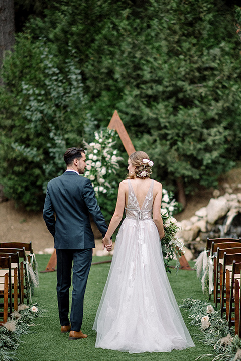  garden themed wedding with the bride in a light lilac colored gown and the groom in a navy suit with lots of wedding day flowers 