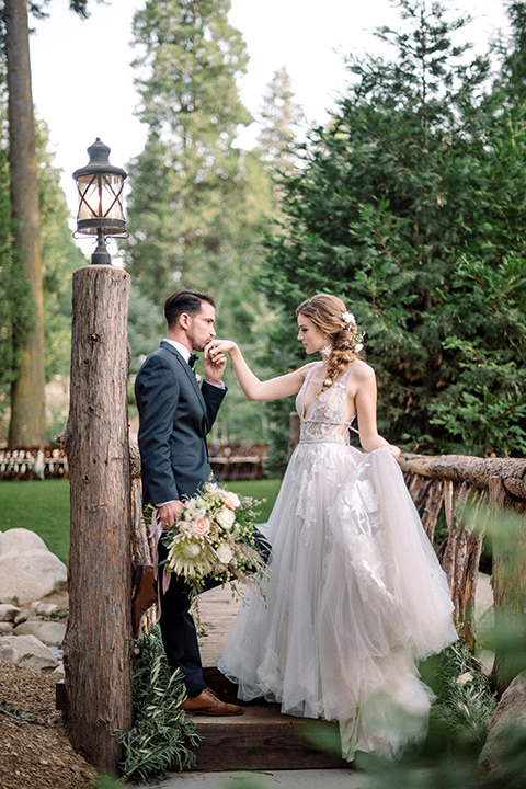  garden themed wedding with the bride in a light lilac colored gown and the groom in a navy suit with lots of wedding day flowers