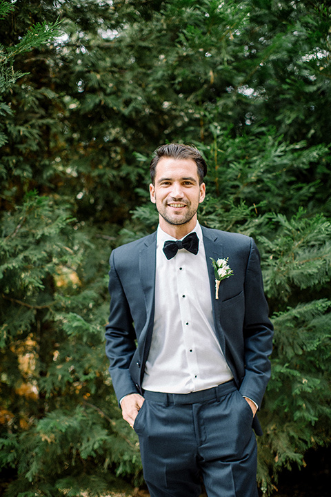  garden themed wedding with the bride in a light lilac colored gown and the groom in a navy suit with lots of wedding day flowers 