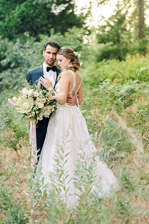  garden themed wedding with the bride in a light lilac colored gown and the groom in a navy suit with lots of wedding day flowers 