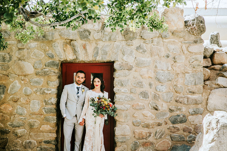  bohemian wedding at a fish hatchery and the bride in a rue de sine gown and the groom in a light grey suit 