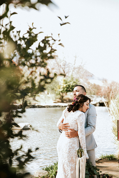  bohemian wedding at a fish hatchery and the bride in a rue de sine gown and the groom in a light grey suit 