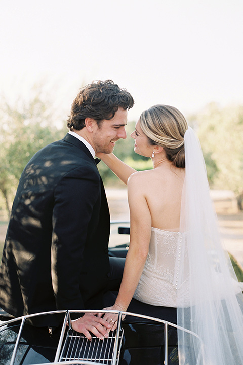  bride in a trumpet gown and her hair in a bun and the groom in a classic black tuxedo and black bow tie 