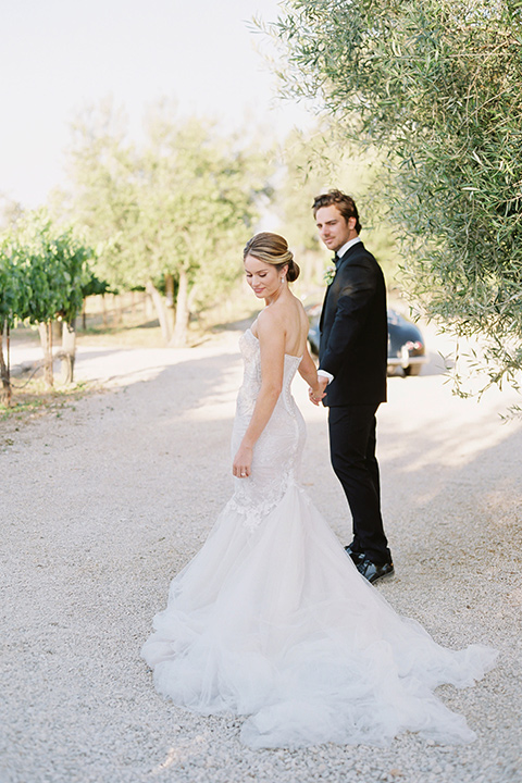  bride in a trumpet gown and her hair in a bun and the groom in a classic black tuxedo and black bow tie 