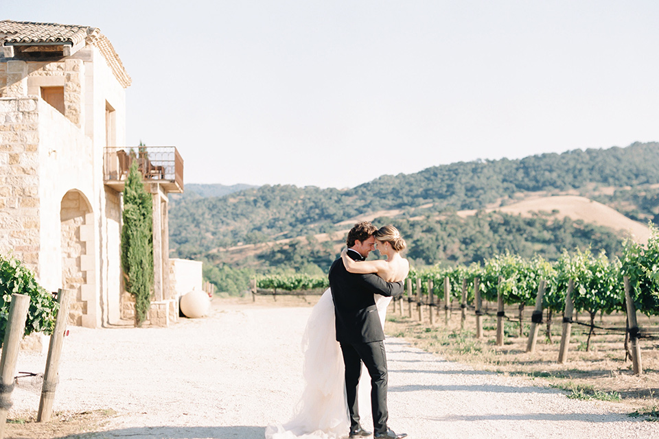  bride in a trumpet gown and her hair in a bun and the groom in a classic black tuxedo and black bow tie 