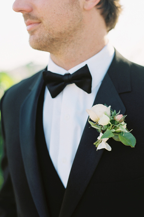  bride in a trumpet gown and her hair in a bun and the groom in a classic black tuxedo and black bow tie 