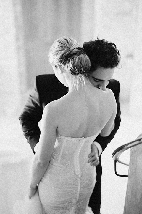  bride in a trumpet gown and her hair in a bun and the groom in a classic black tuxedo and black bow tie 