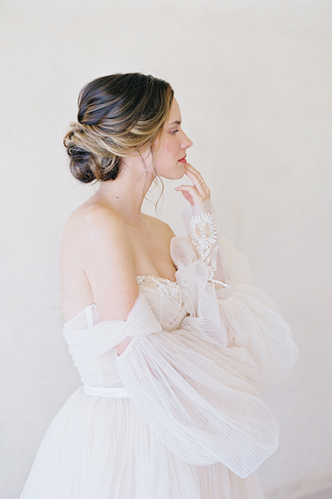  wedding at sunstone winery with romantic details and the groom in a café brown suit and the bride in a flowing ballgown with billowing sleeves