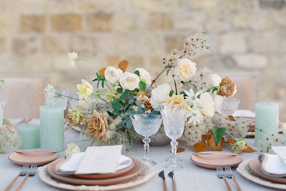  wedding at sunstone winery with romantic details and the groom in a café brown suit and the bride in a flowing ballgown with billowing sleeves 