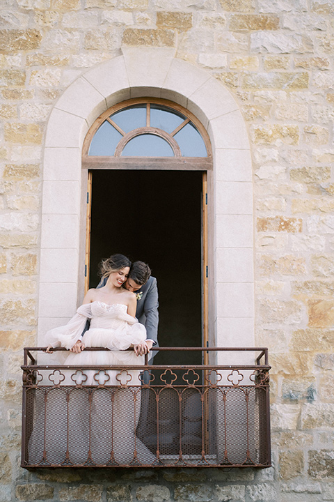  wedding at sunstone winery with romantic details and the groom in a café brown suit and the bride in a flowing ballgown with billowing sleeves