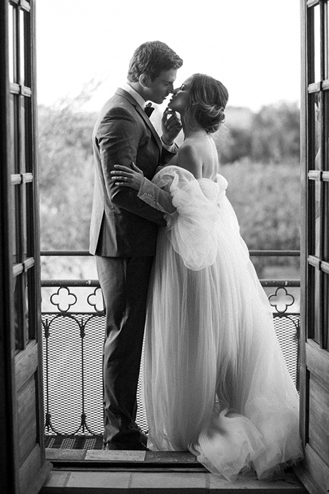  wedding at sunstone winery with romantic details and the groom in a café brown suit and the bride in a flowing ballgown with billowing sleeves 