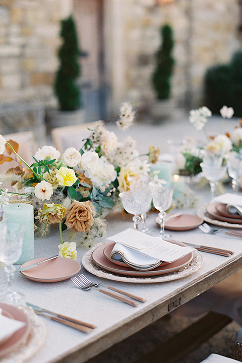  wedding at sunstone winery with romantic details and the groom in a café brown suit and the bride in a flowing ballgown with billowing sleeves 