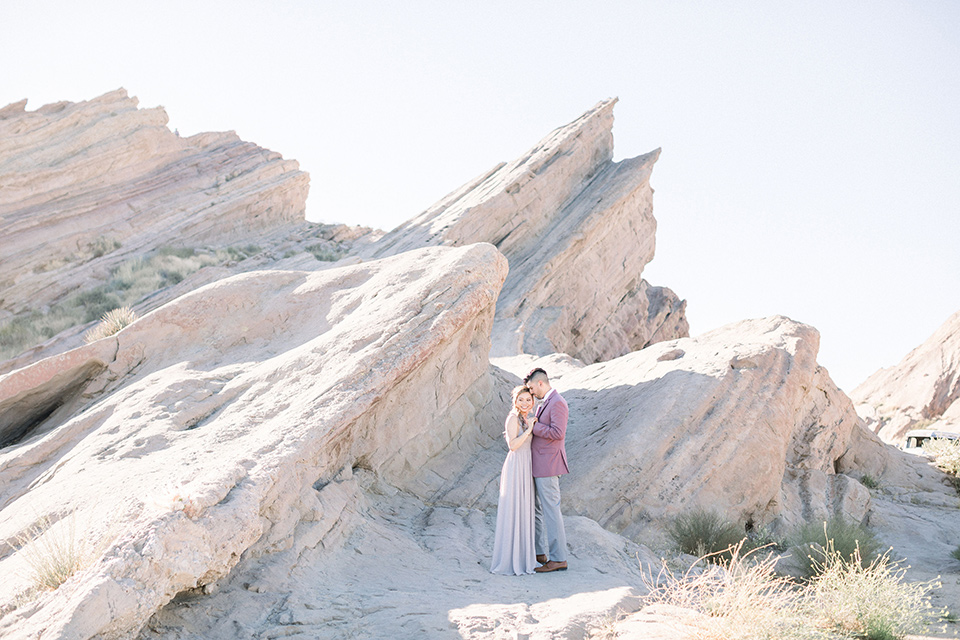  bride in a soft lilac colored gown for a dessert elopement and the groom in a rose pink suit and grey pants 