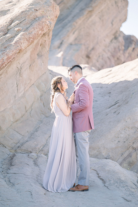  bride in a soft lilac colored gown for a dessert elopement and the groom in a rose pink suit and grey pants 