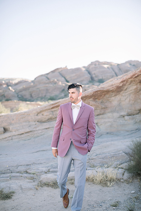  bride in a soft lilac colored gown for a dessert elopement and the groom in a rose pink suit and grey pants