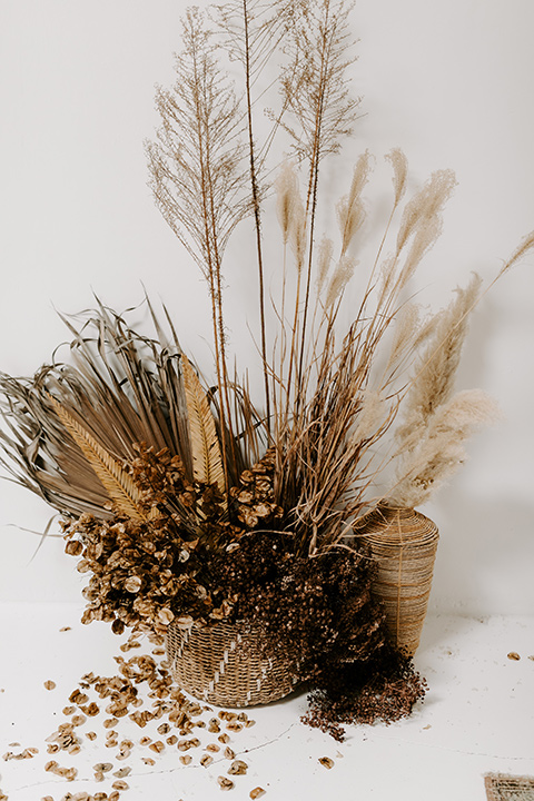  boho wedding with the ceremony inside and the reception on the cliffs overlooking the ocean and the bride in a finged gown and the groom in a tan suit 