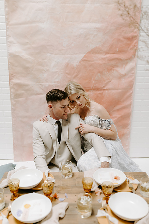  boho wedding with the ceremony inside and the reception on the cliffs overlooking the ocean and the bride in a finged gown and the groom in a tan suit 