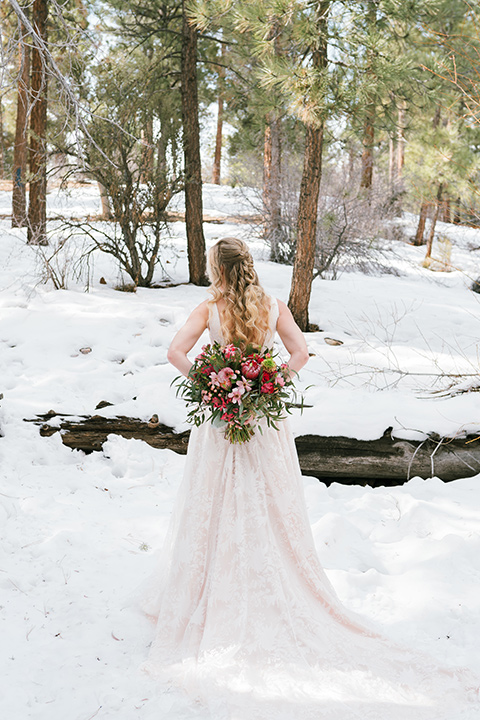  big bear elopement in the snow with the bride is a lace gown and the groom in a green suit – bride twirling 