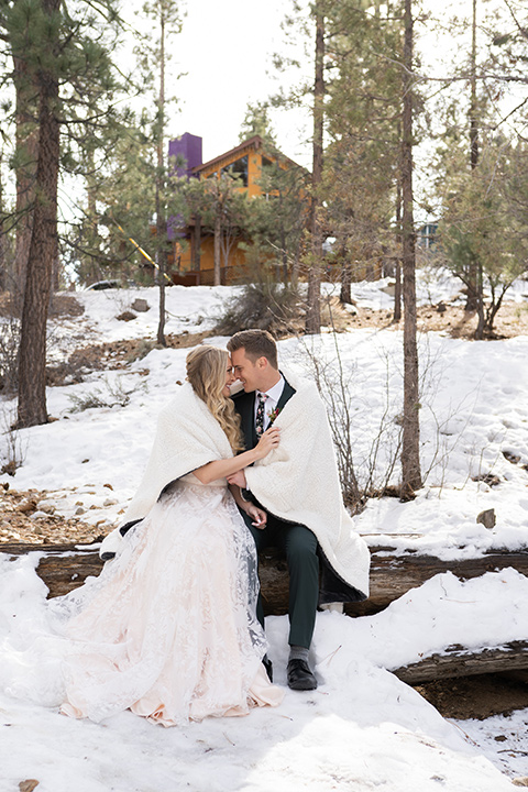  big bear elopement in the snow with the bride is a lace gown and the groom in a green suit – couple in the snow 