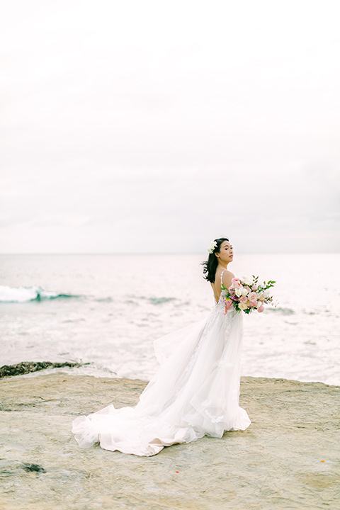  a coastal beach theme with a blush and beige wedding color scheme – bride in her gown 