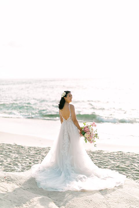  a coastal beach theme with a blush and beige wedding color scheme – bride in her gown 