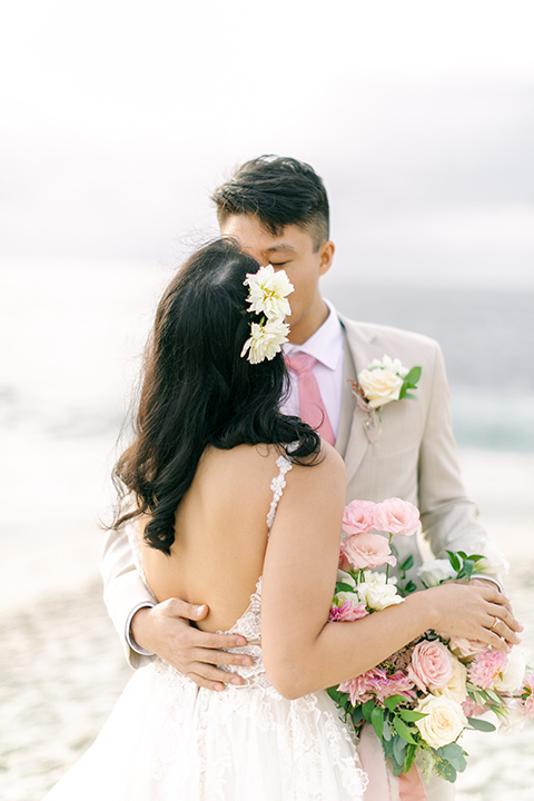  a coastal beach theme with a blush and beige wedding color scheme – couple kissing