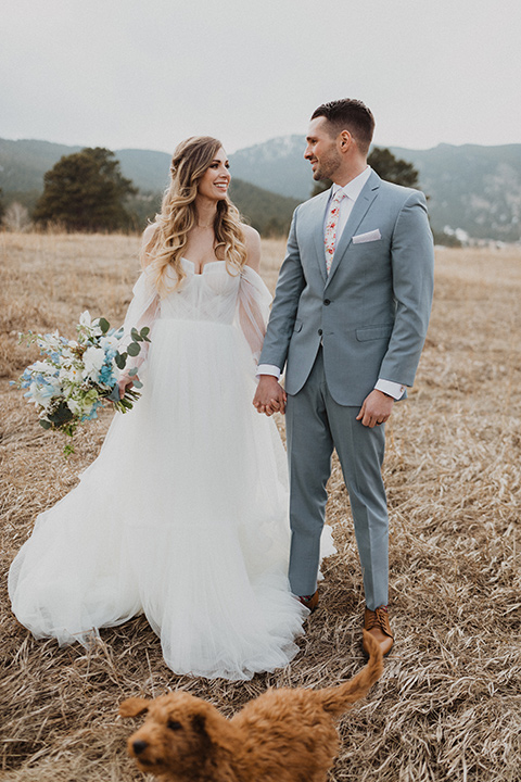  couple walking their dog at their elopement in a meadow in Colorado