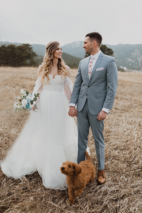  couple walking their dog at their elopement in a meadow in Colorado 
