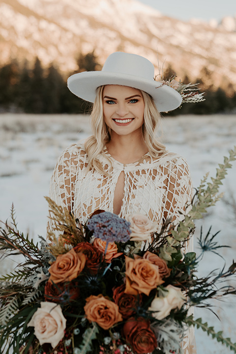  grand tetons elopement in the winter with snow on the ground with the bride in a lace gown and the groom in a rose pink suit – bride in a hat 