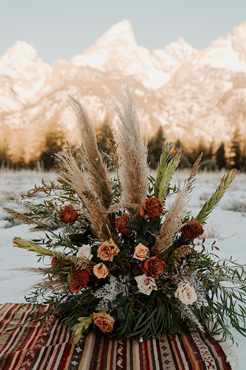  grand tetons elopement in the winter with snow on the ground with the bride in a lace gown and the groom in a rose pink suit – ceremony space