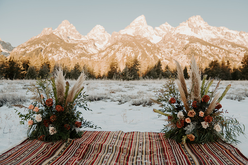  grand tetons elopement in the winter with snow on the ground with the bride in a lace gown and the groom in a rose pink suit – ceremony space 
