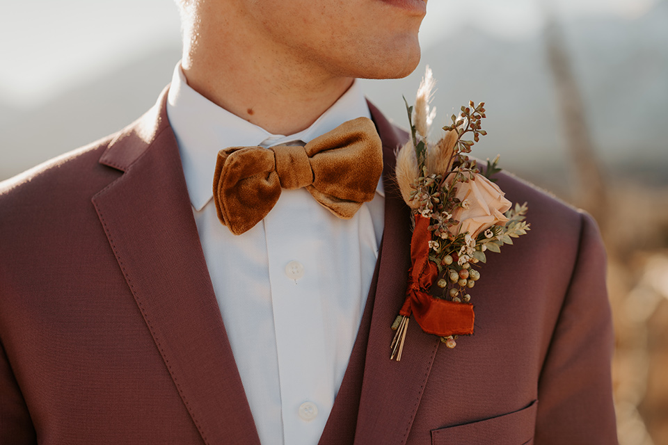  grand tetons elopement in the winter with snow on the ground with the bride in a lace gown and the groom in a rose pink suit – groom close 