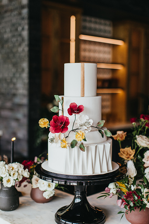  modern and colorful wedding with the bride in an off-the-shoulder dress and the groom in an all-black tuxedo – cake