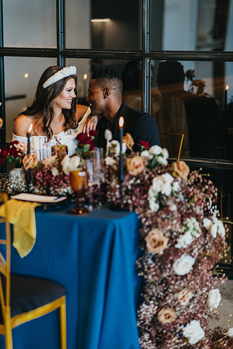  modern and colorful wedding with the bride in an off-the-shoulder dress and the groom in an all-black tuxedo – couple at the recpetion