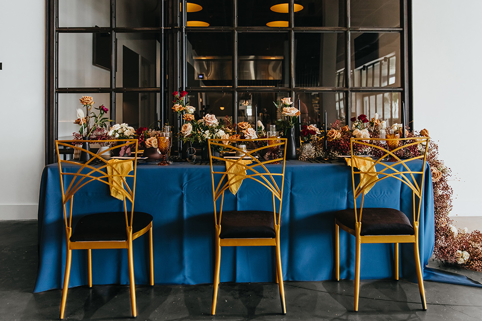  modern and colorful wedding with the bride in an off-the-shoulder dress and the groom in an all-black tuxedo – reception tables 