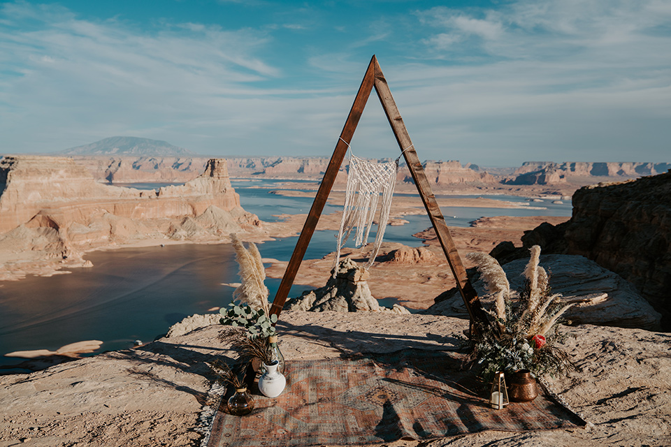  a boho wedding at lake powell with the bride in a bohemian gown and a wide brimmed hat and the groom in a gold velvet jacket – ceremony space