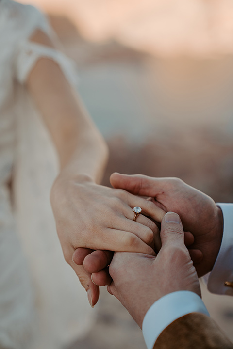  a boho wedding at lake powell with the bride in a bohemian gown and a wide brimmed hat and the groom in a gold velvet jacket – couple at wedding ceremony 