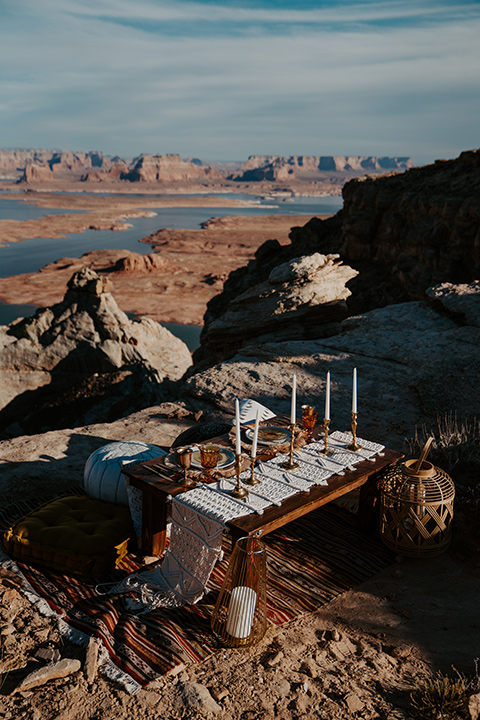  a boho wedding at lake powell with the bride in a bohemian gown and a wide brimmed hat and the groom in a gold velvet jacket – reception décor